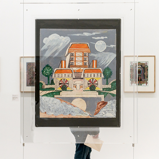 Salle d'exposition avec deux toiles au mur et un dessin sous plexi glace au centre.