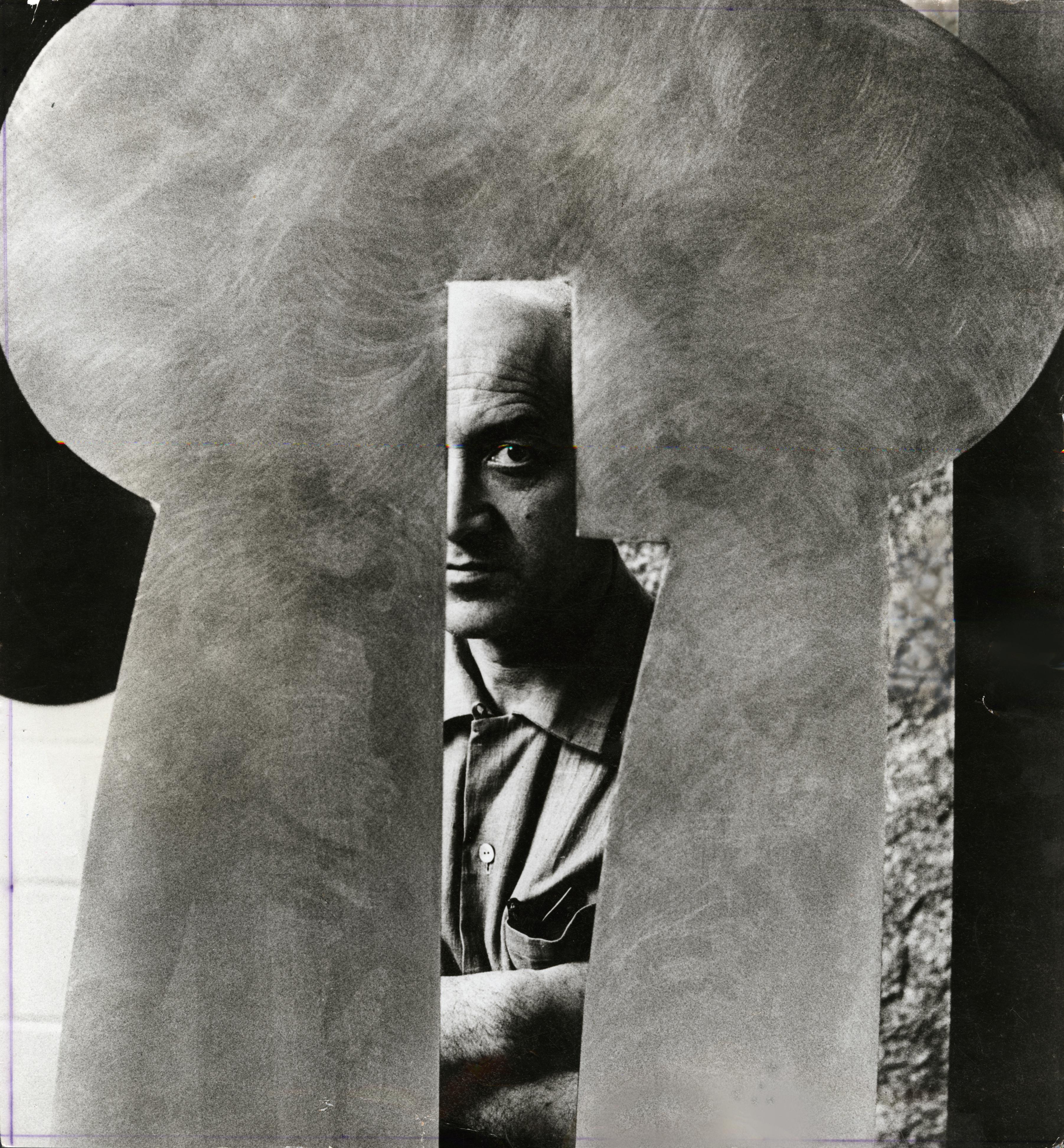 Portrait de Isamu Noguchi en noir et blanc à travers une de ses sculpture.