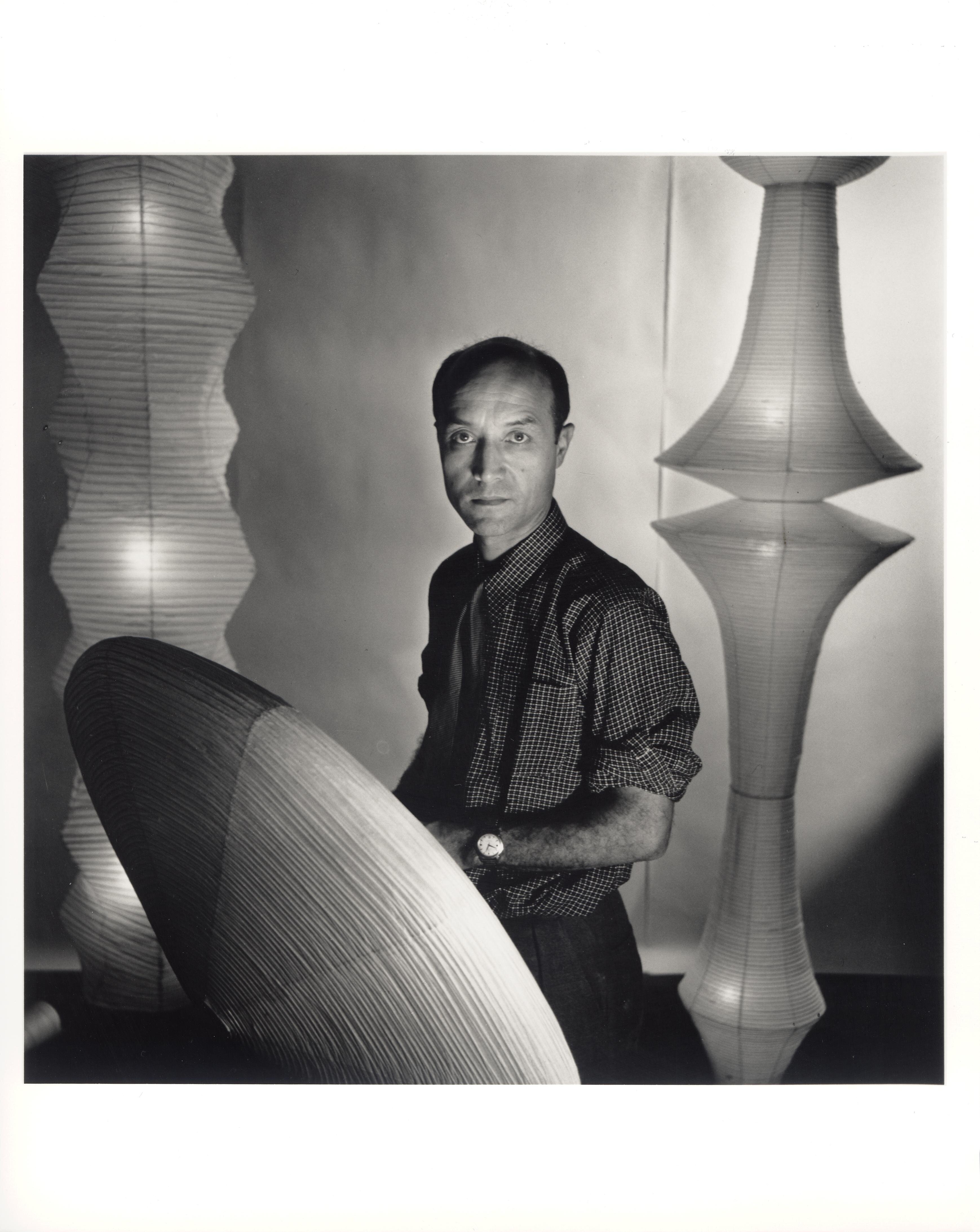 Portrait de Isamu Noguchi entouré de ses sculptures.