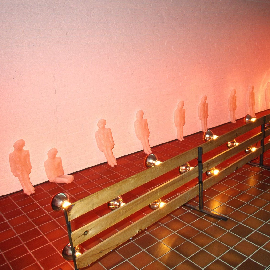 Sculpture miniature de cire devant des lampes chauffantes.