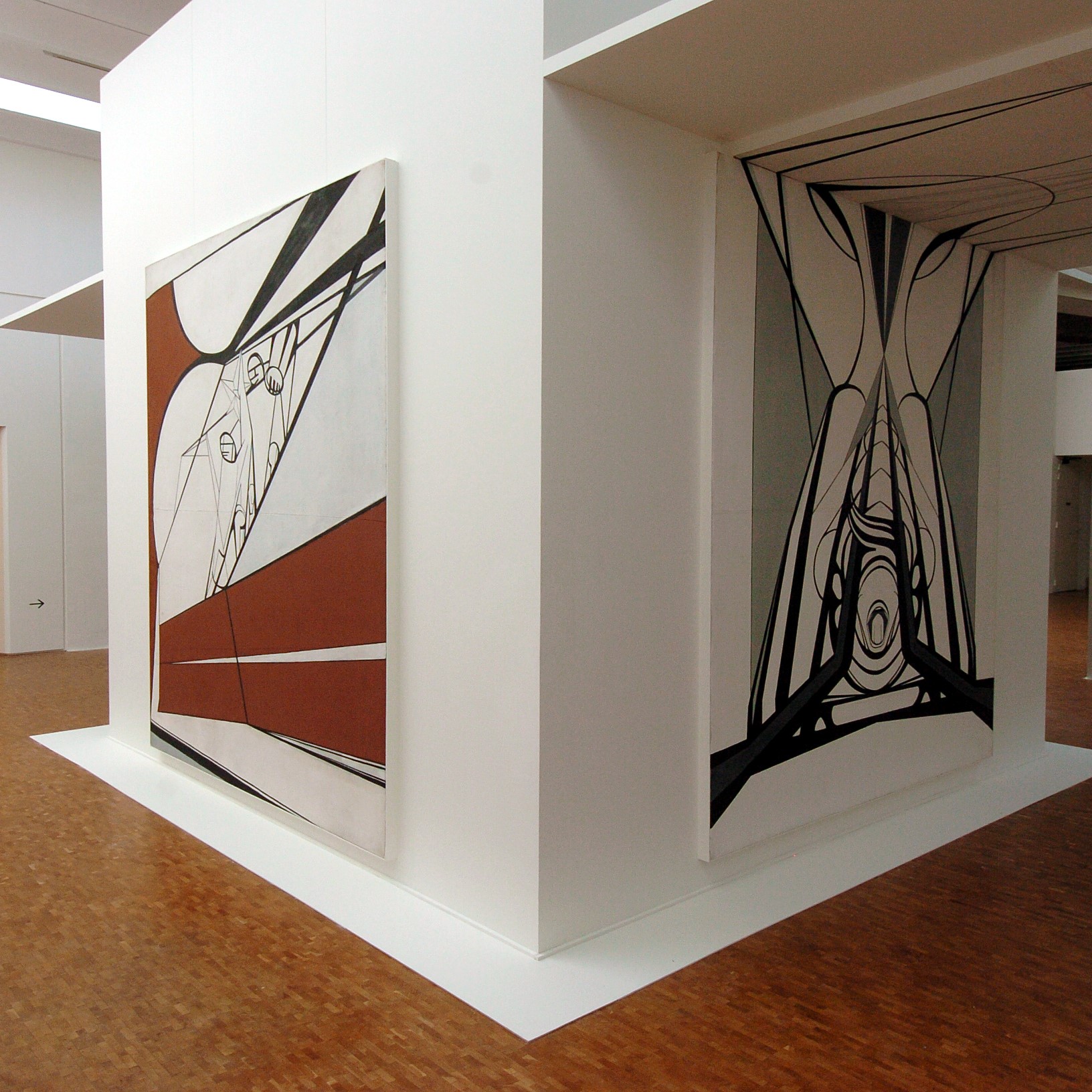 Salle d'exposition avec toiles aux murs.