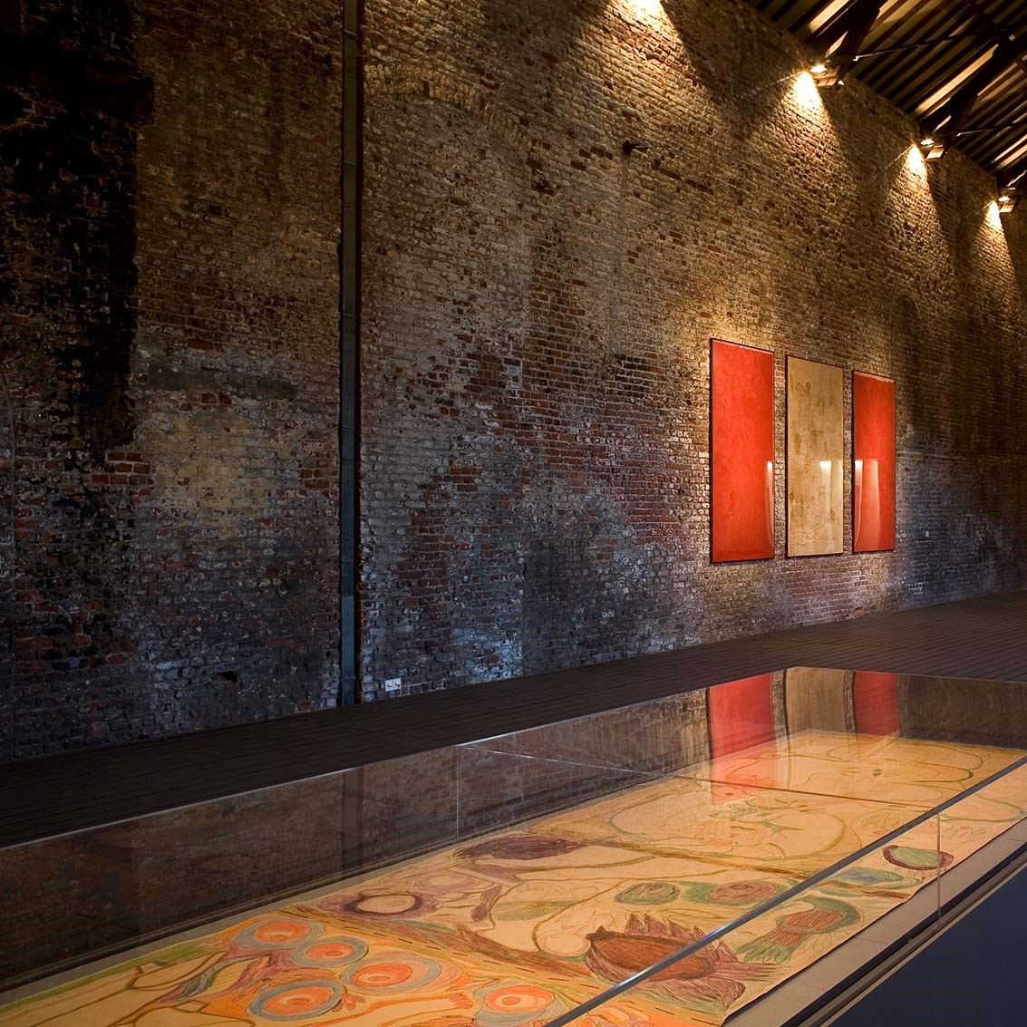 Vitrine et trois toiles en arrière plan.