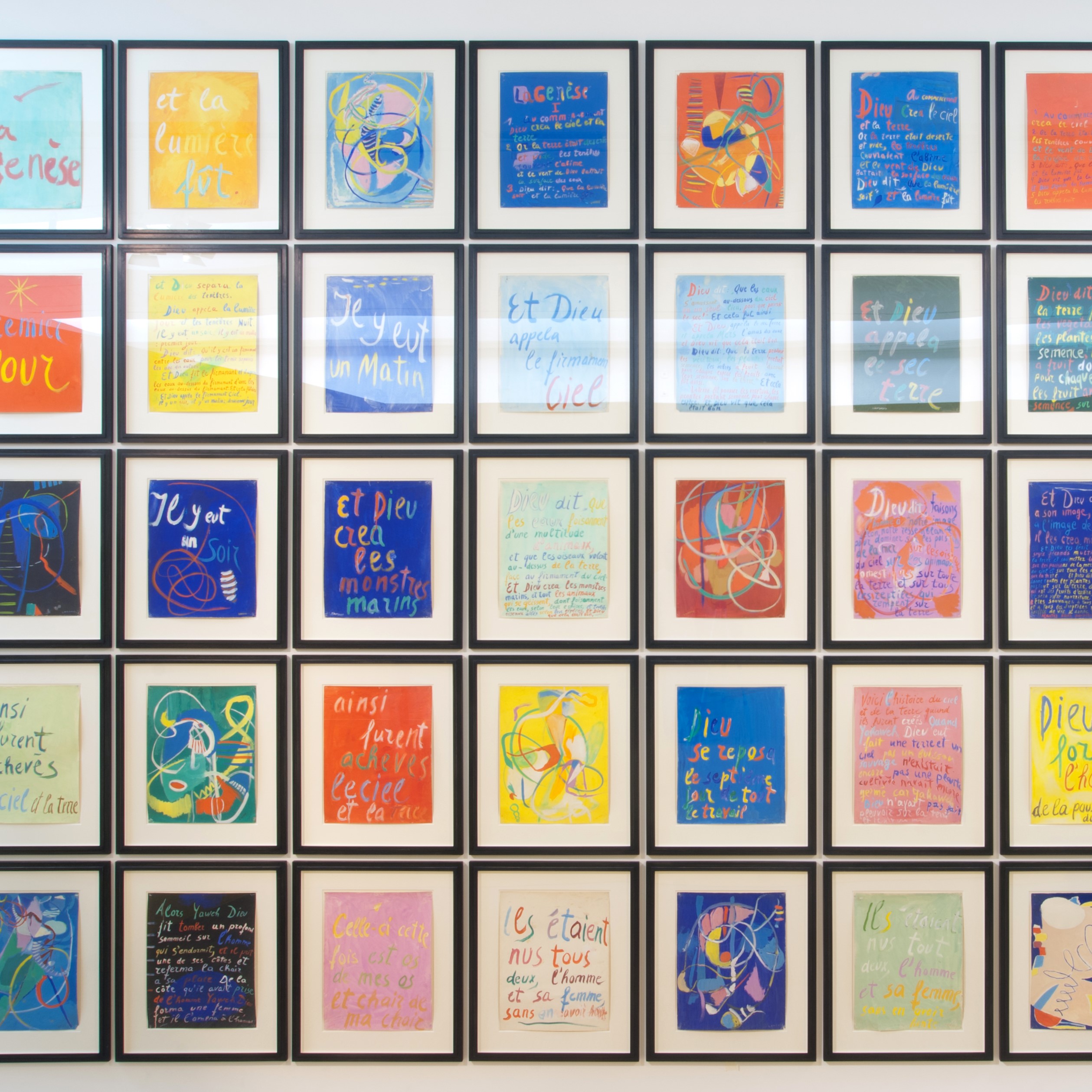 Multitude de cadres et de dessins multicolores sur un mur d'exposition.