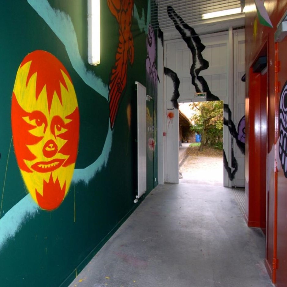 Couloir menant sur l'extérieur avec mur peint.