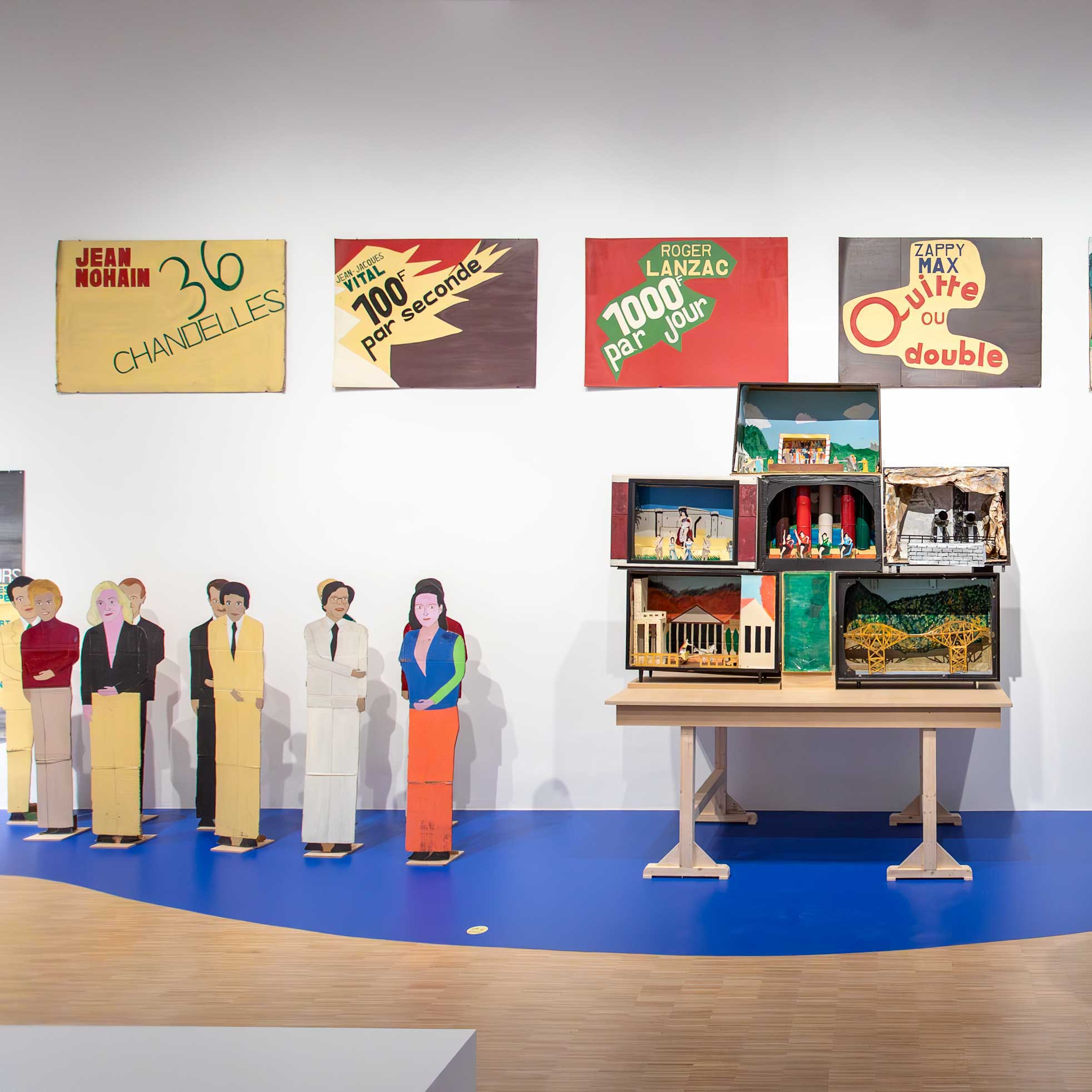 Vue de l'exposition de Guy Brunet. Un visiteur regardant des œuvres accrochées au mur.