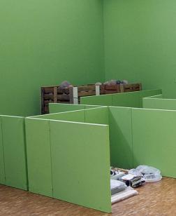 Salle d'exposition verte en accrochage.