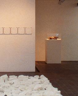 Salle d'exposition du musée avec un centre composé de pierres blanches.