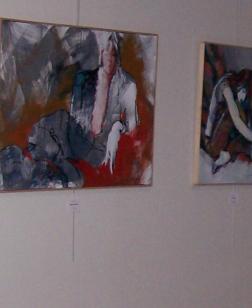 Salle d'exposition et deux tableaux accrochés au mur.