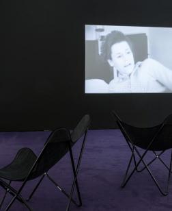 Salle d'exposition du musée où se déroule une projection sur écrans et sur projecteur.