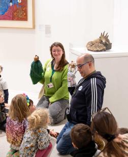 Groupe d'enfants regardant les guides avec des marionnettes et les œuvres du musée dans le cadre d'un atelier.