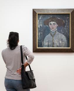 Une femme devant une œuvre du musée dans une des salles de la collection permanente.