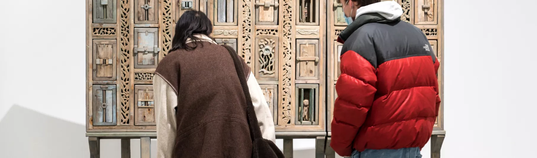 Œuvre en bois avec une multitudes de petites portes.