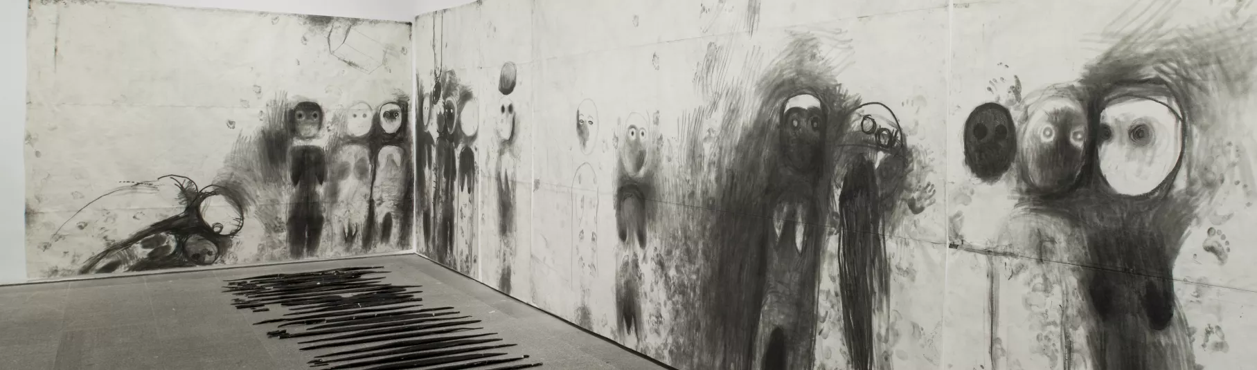 Miriam Cahn, salle d'exposition avec fresque de dessin noir sur fond blanc.