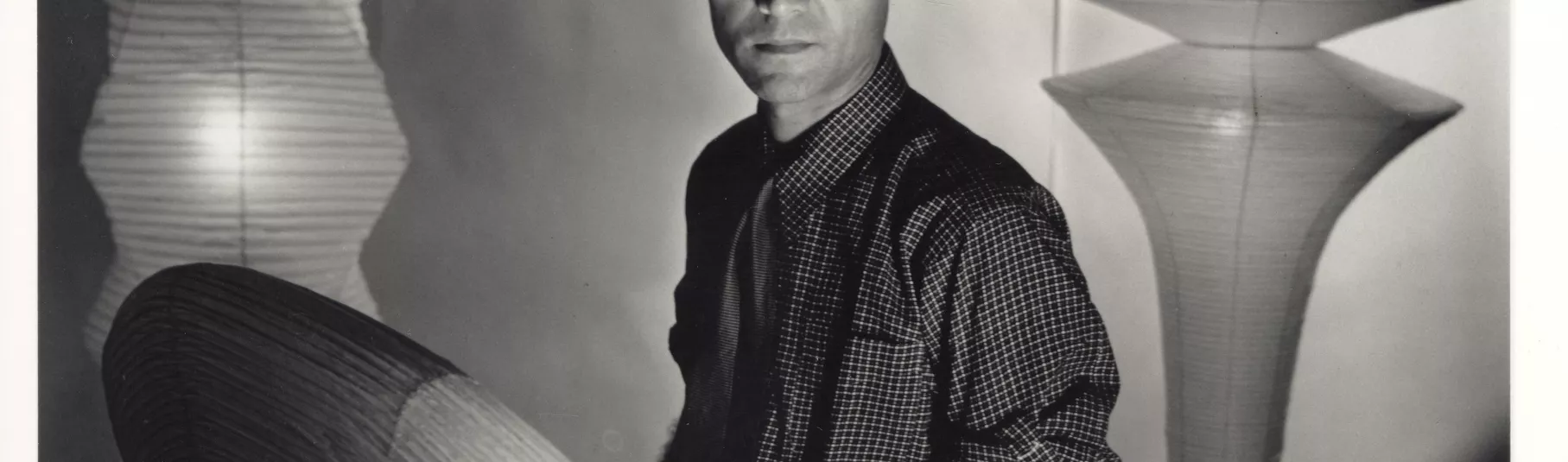 Portrait de Isamu Noguchi entouré de ses sculptures.