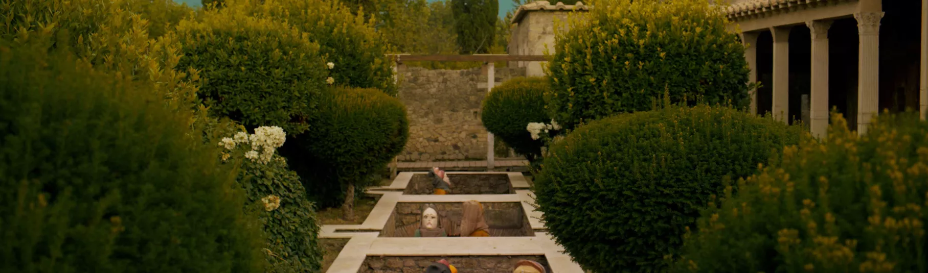 Extrait du film de Wael Shawky "I Am Hymns of The New Temples". Vue en contre plongée des personnages entourés de buissons.