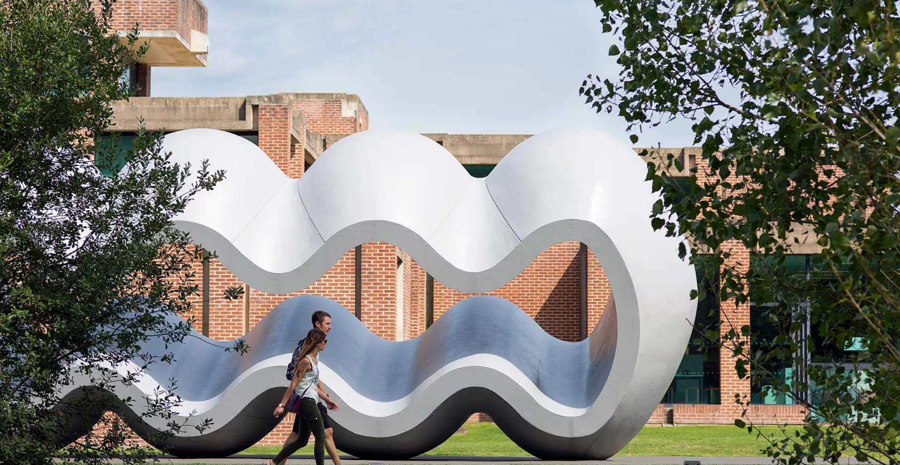Public dans le parc du LaM devant la sculpture Between Fiction and Fact de Richard Deacon