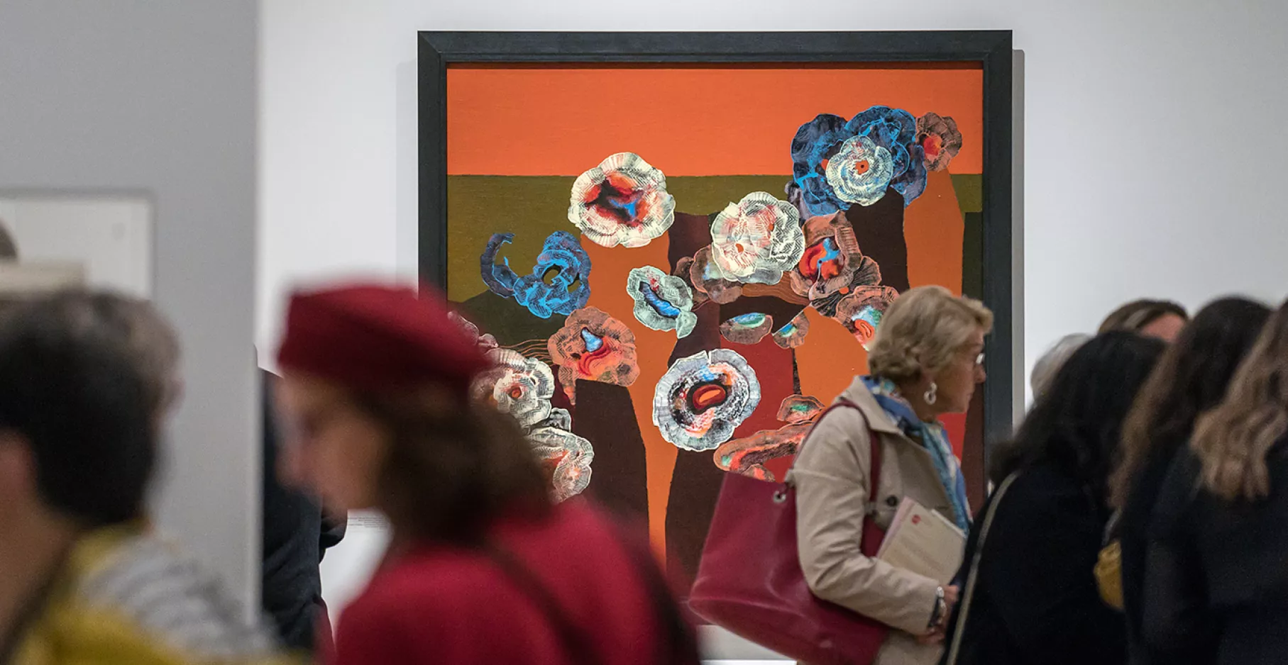 Visiteurs passant devant une toile.