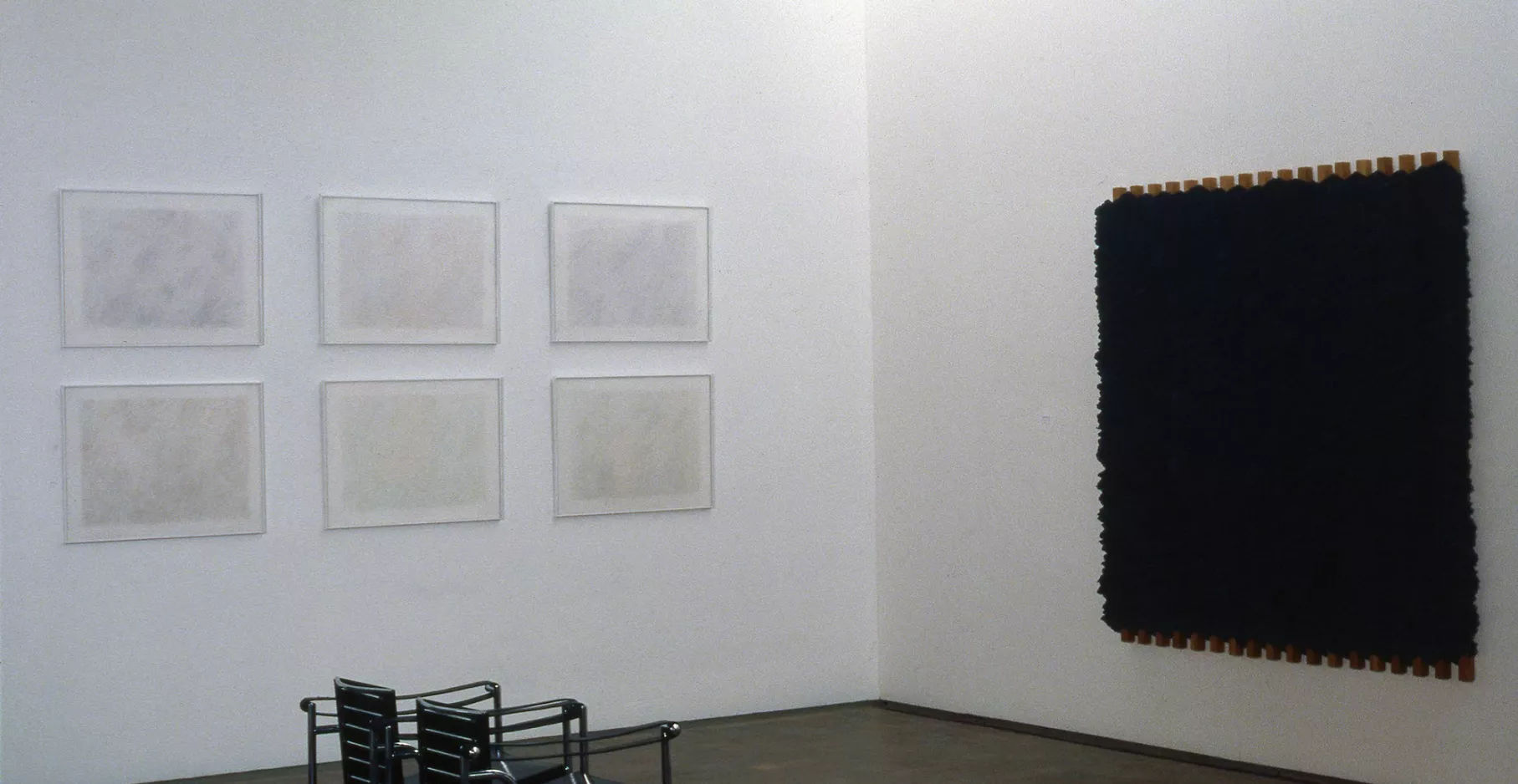 Salle d'exposition présentant des œuvres aux murs.