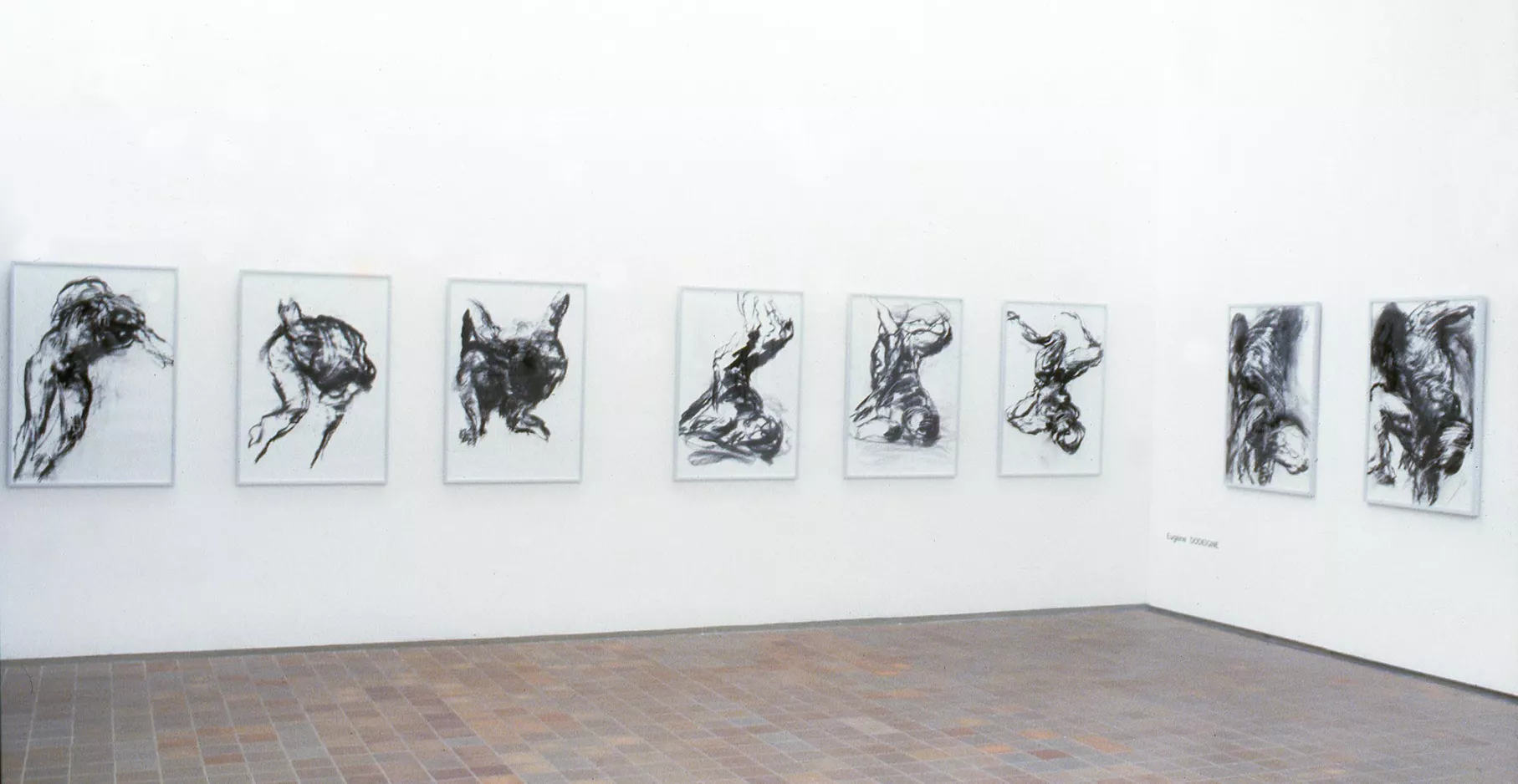 Salle d'exposition avec des dessins aux murs.