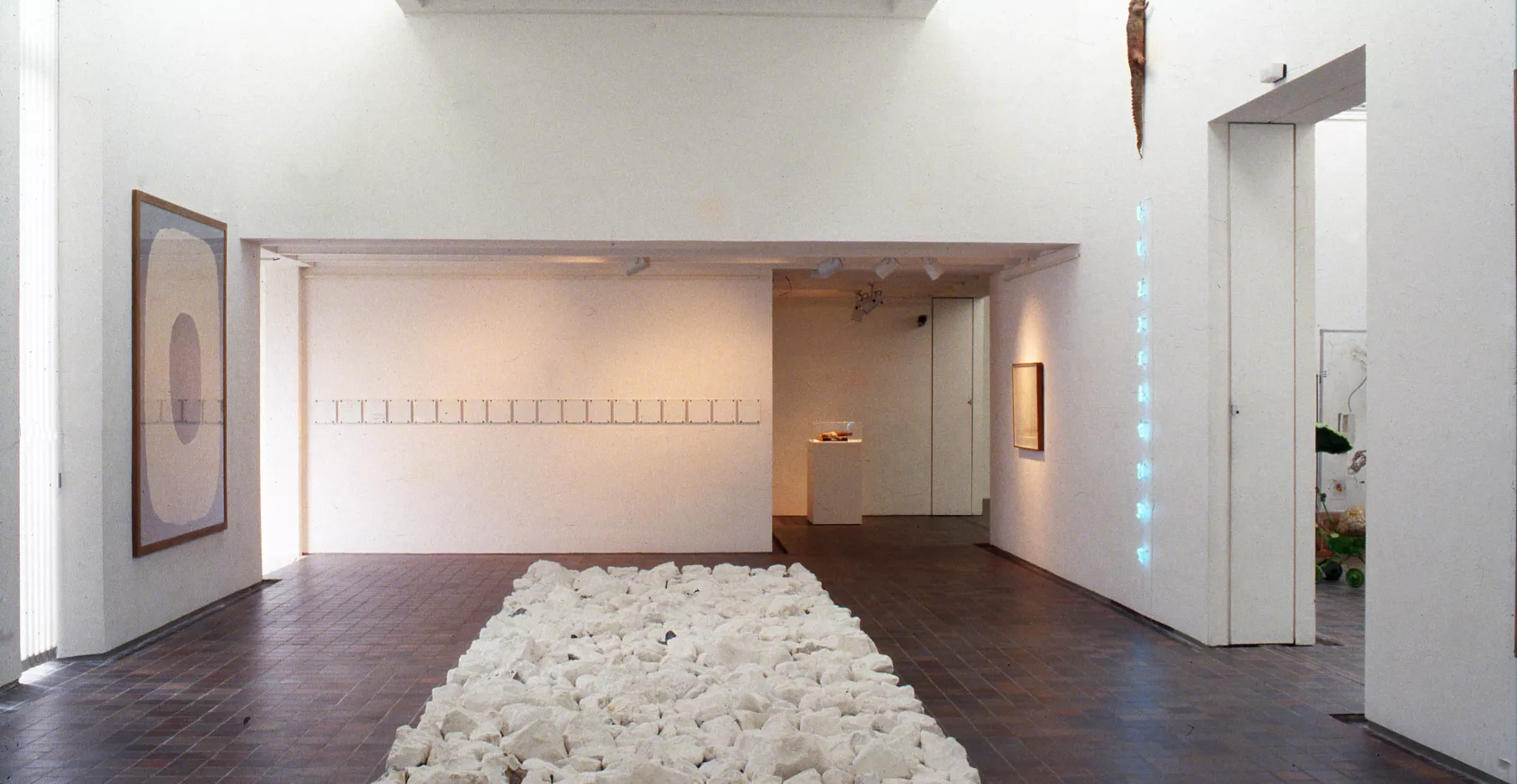 Salle d'exposition du musée avec un centre composé de pierres blanches.