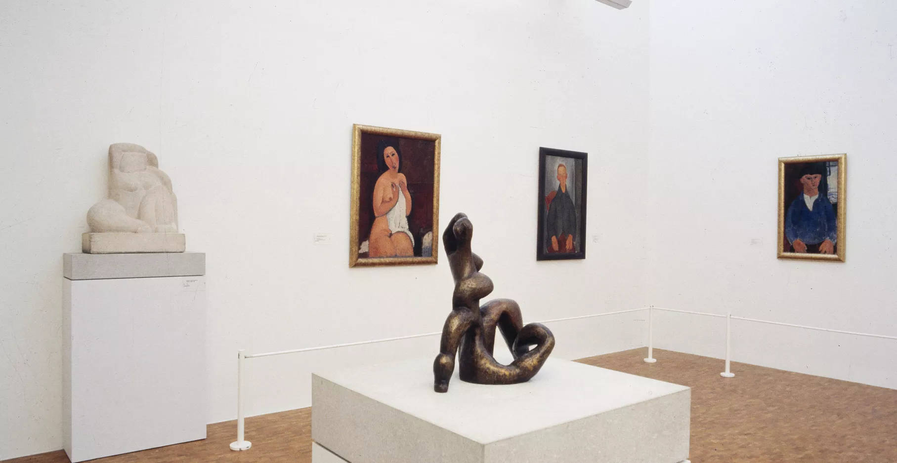 Salle d'exposition présentant des toiles et des sculptures.