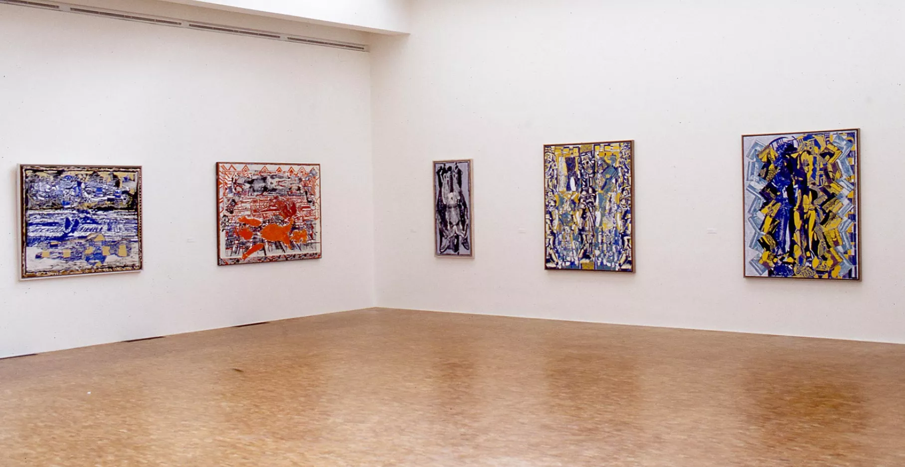 Salle d'exposition avec des tableaux aux murs.