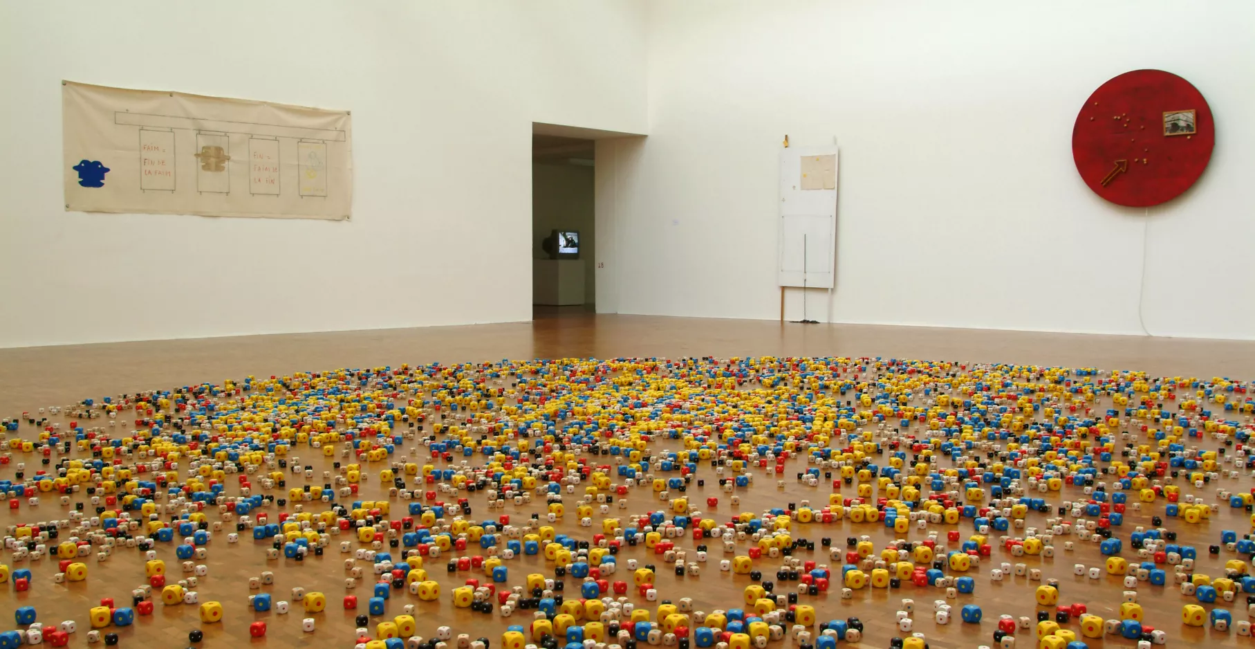 Salle d'exposition remplit de dés au sol.
