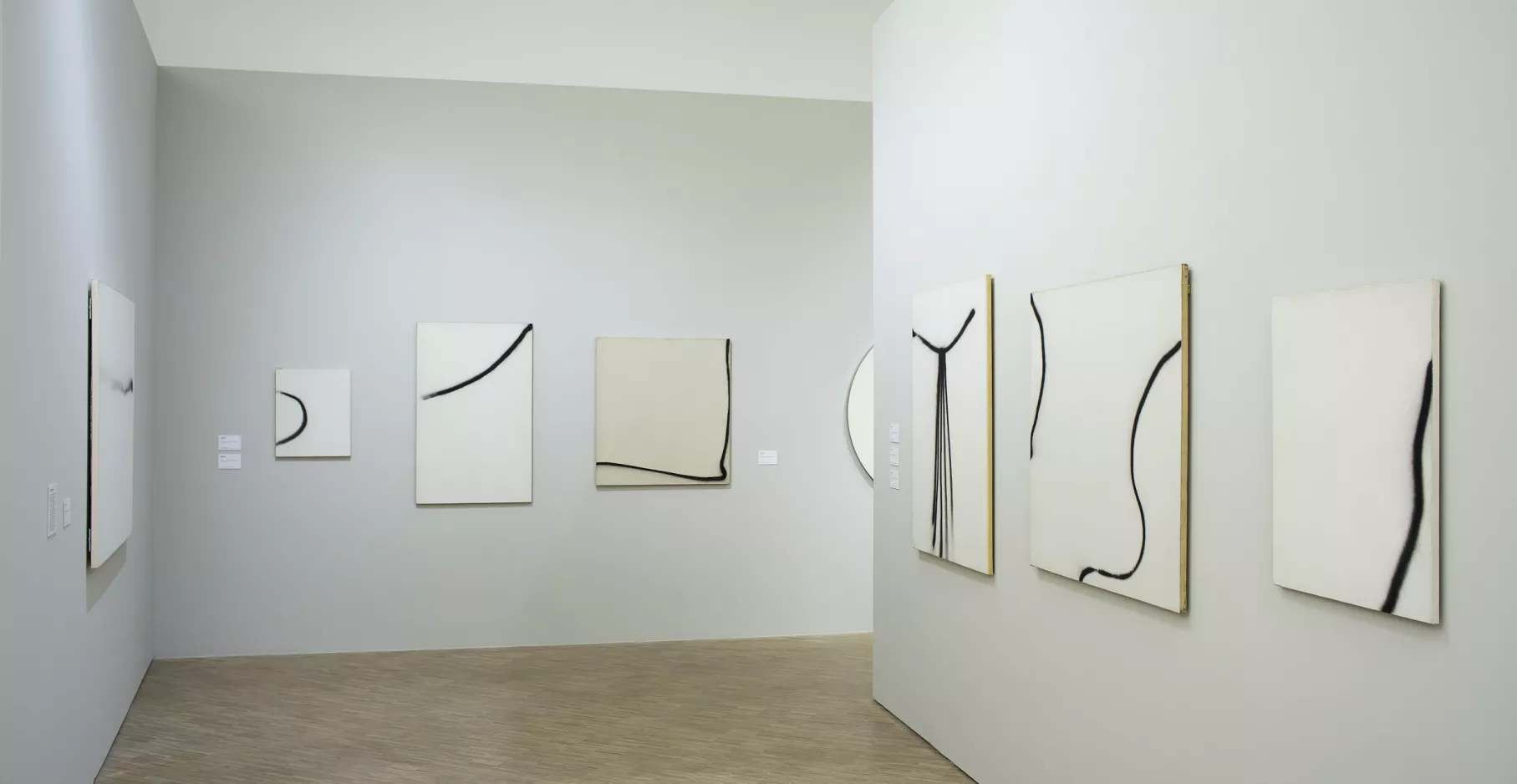 Toiles noires et blanches dans une salle d'exposition.