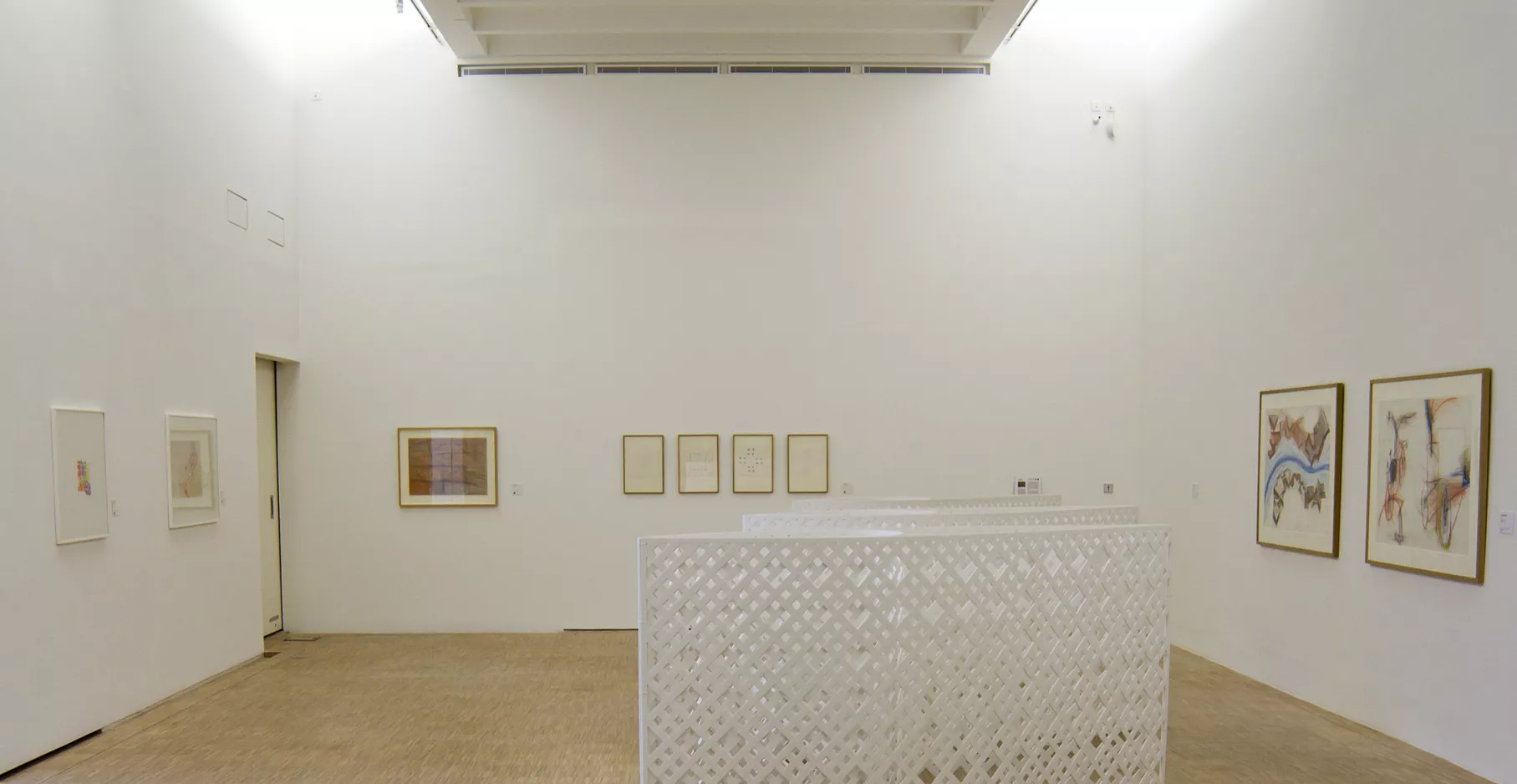 Salle d'exposition avec sculptures et toiles.