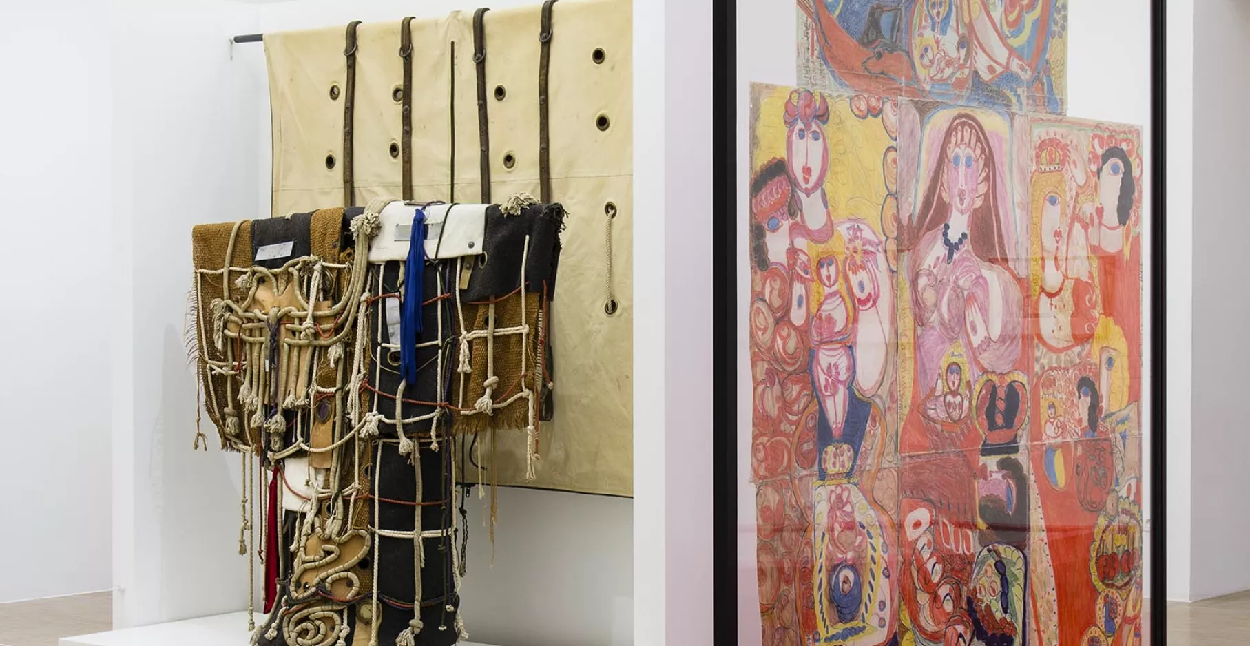 Salle d'exposition avec dessin et installation de tissus.