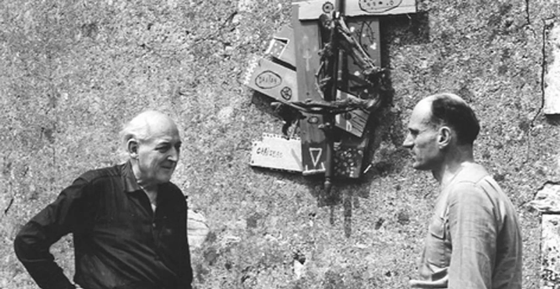 Photographie en noir et blanc avec deux hommes se regardant se profil.
