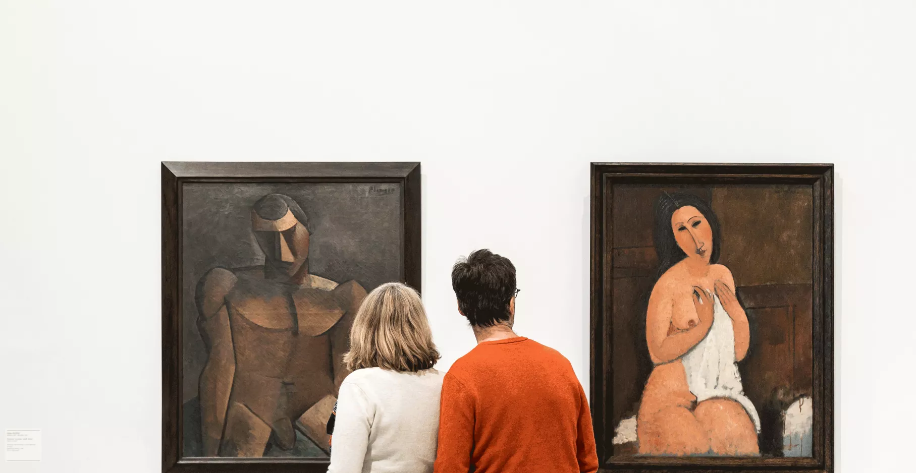 Deux personnes devant une œuvre du musée dans une des salles de la collection permanente.